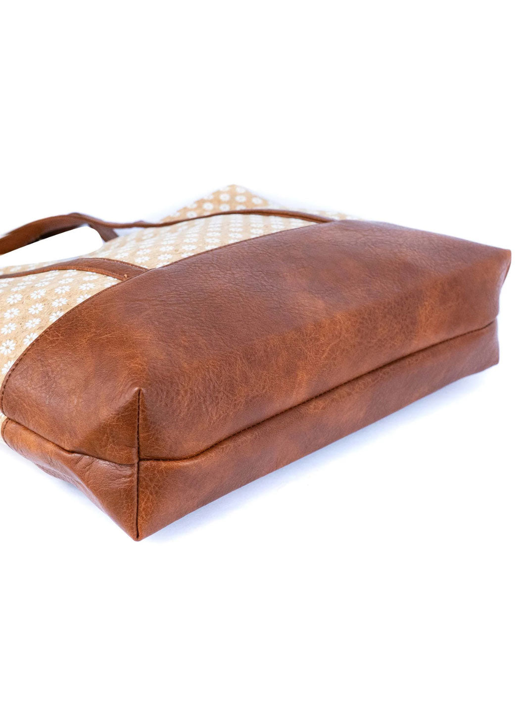 Brown leather bag with a polka dot lining on a white background