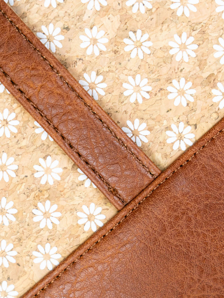 Close-up of a brown leather strap and beige fabric with white floral pattern