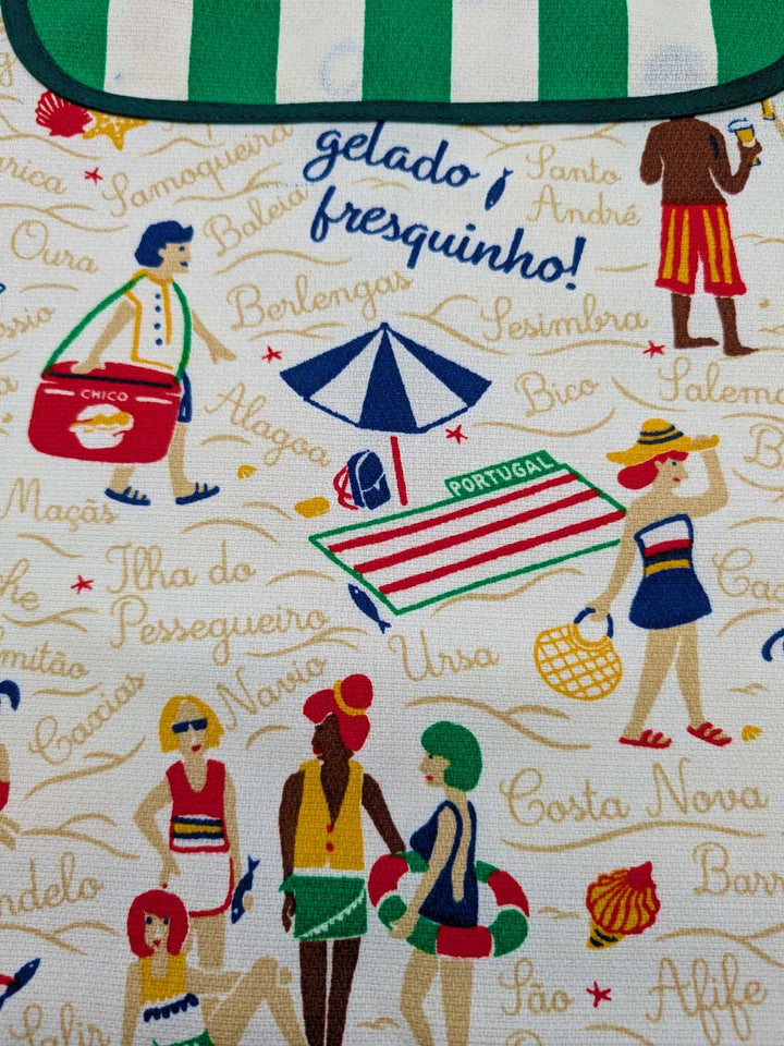 Fabric with beach-themed design featuring people, umbrellas, and text in a decorative pattern.