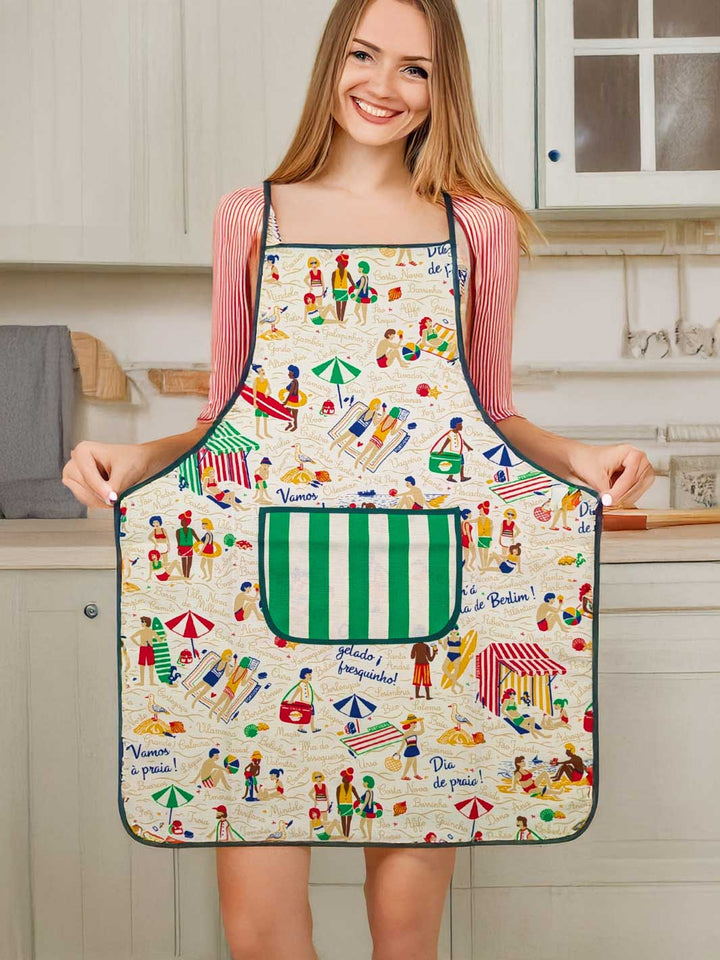 Woman wearing a colorful apron with a beach theme in a kitchen.