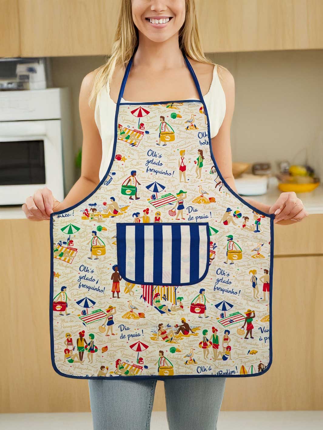 Person wearing a colorful apron with beach-themed design in a kitchen.