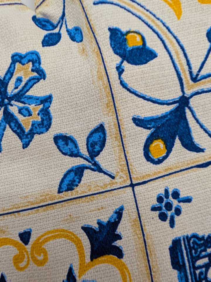 Close-up of decorative tiles with blue and yellow patterns on a beige background
