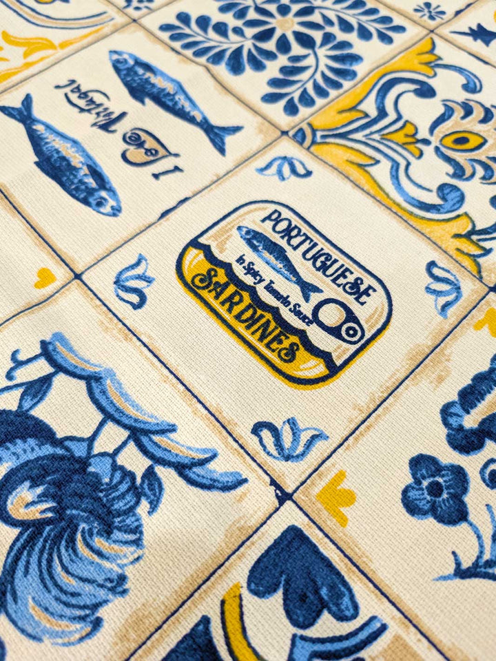 Close-up of decorative tiles with blue fish and yellow accents, featuring a Portuguese Sardines label.