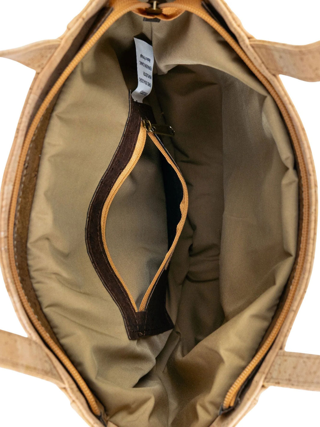 Open brown leather bag with a tag inside, on a white background