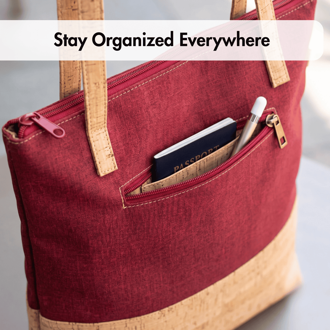 Red cork tote bag with brown handles containing a passport and other items, with text 'Stay Organized Everywhere'.
