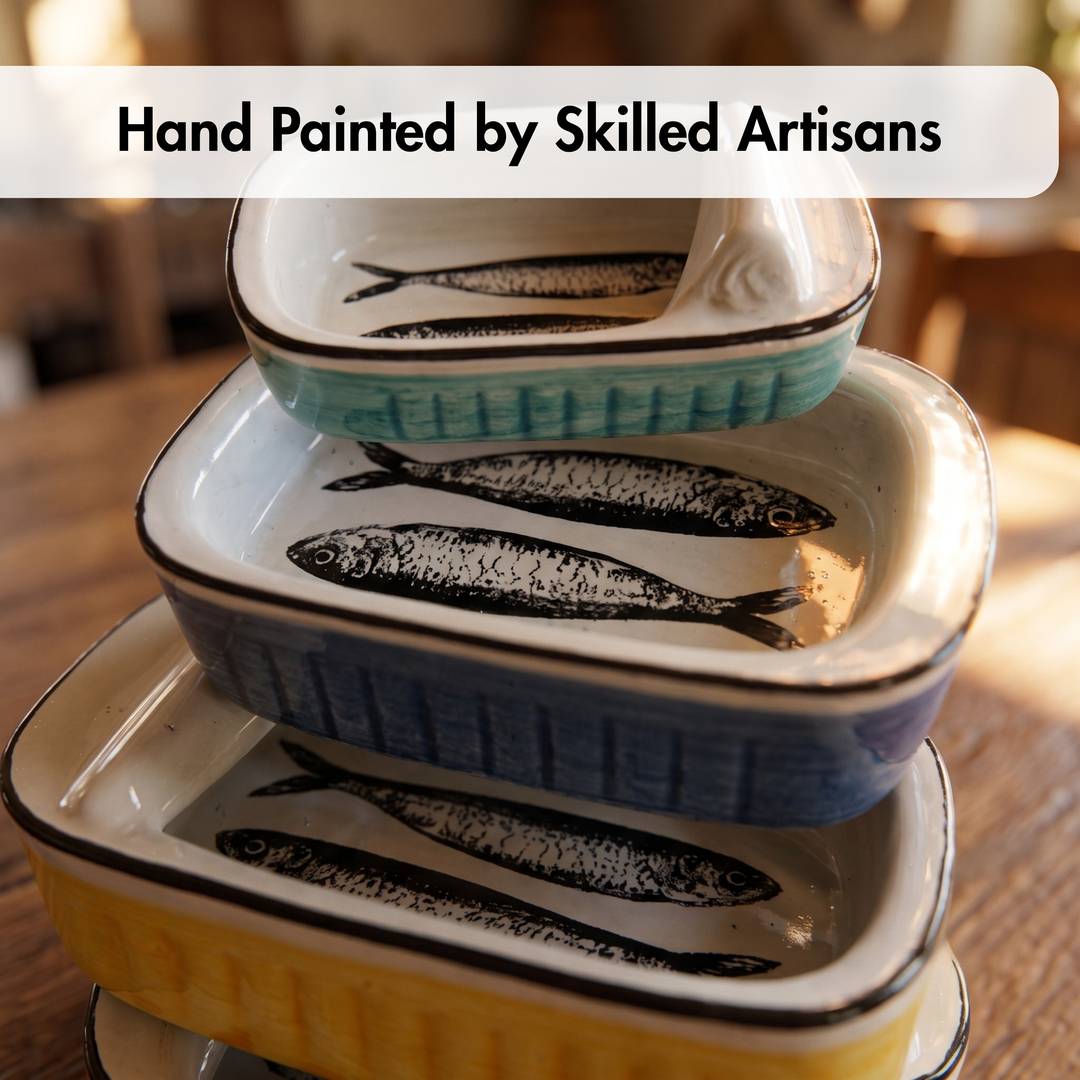 Three stacked rectangular ceramic dishes with a hand-painted fish design, shown on a wooden table. The top dish is light blue, the middle is blue, and the bottom is yellow.