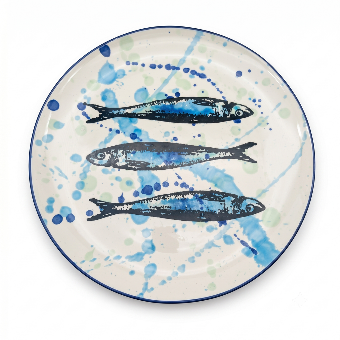 Ceramic plate with fish design and blue splatter pattern on a white background