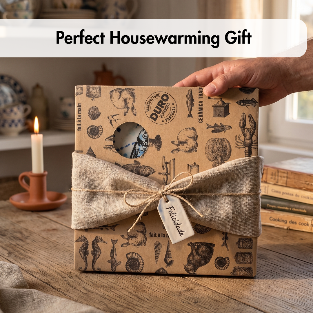 Gift box with decorative wrapping on a wooden surface, labeled as a perfect housewarming gift.