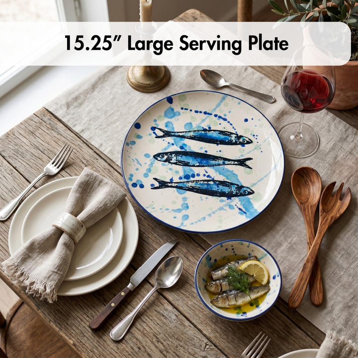 Large serving plate with fish design on a table setting with cutlery and a bowl.