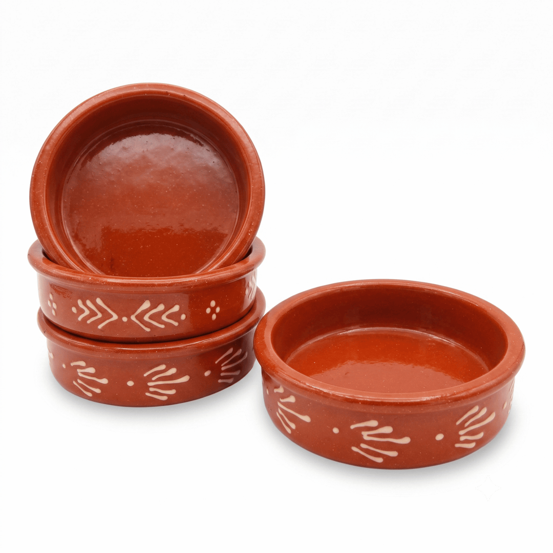 Four small round terracotta clay dishes with white hand-painted decorative patterns, with three stacked on the left and one standing on the right, against a plain white background.