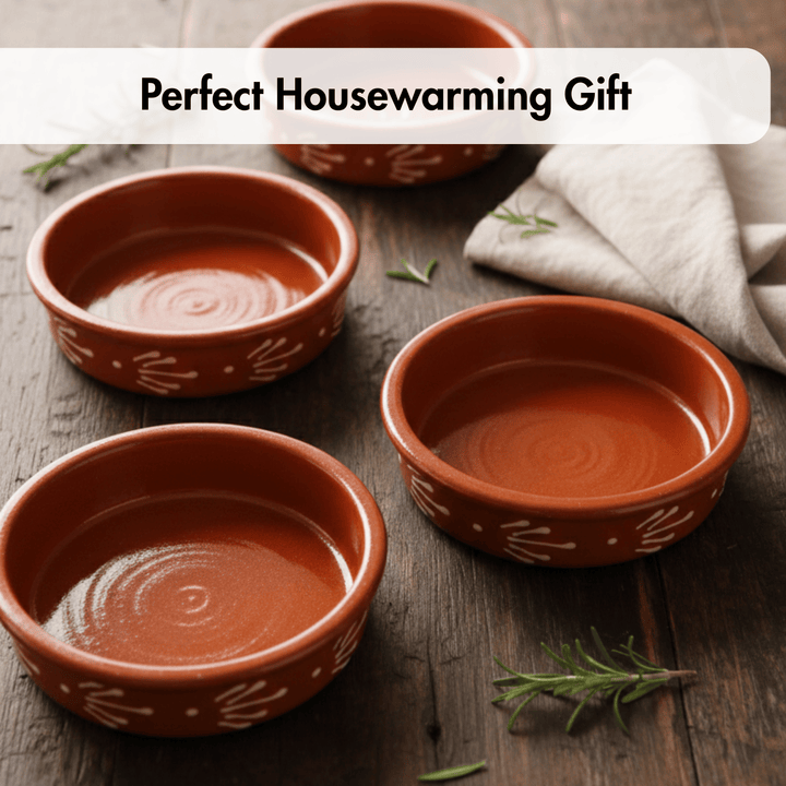 Three terracotta-colored ceramic bowls with white hand-painted leaf patterns are arranged on a dark wooden table with a white cloth and rosemary sprigs. A text banner at the top reads &