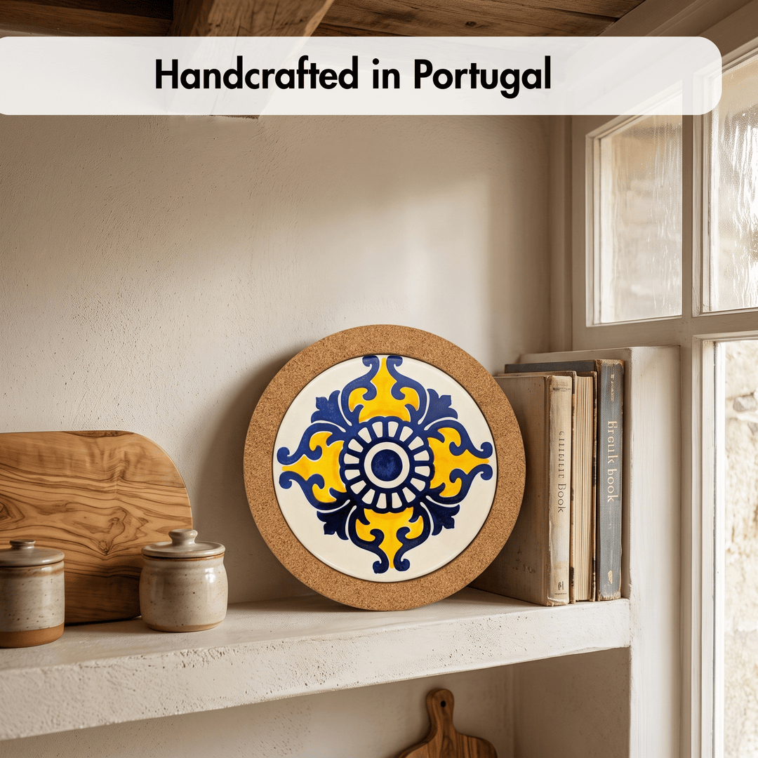A round decorative ceramic tile coaster with a blue and yellow floral pattern on a white center, displayed on a rustic shelf next to books and wooden kitchen items. A text banner at the top reads &