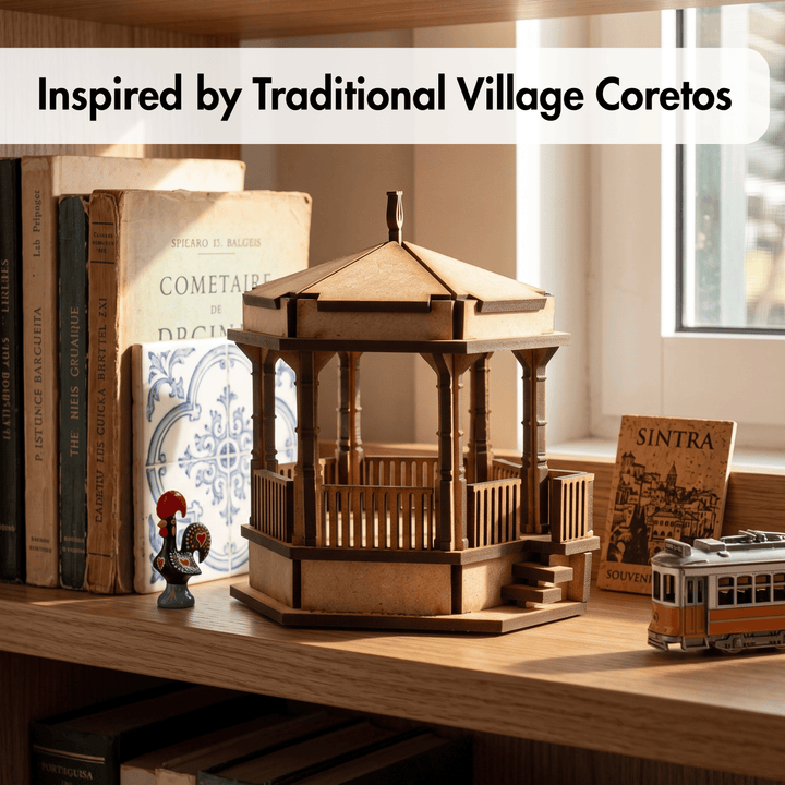 A wooden gazebo-style decorative model sits on a wooden shelf beside vintage books, with a small rooster figurine and a miniature tram. The scene is styled in a warm indoor setting with a window in the background, and text at the top reads &