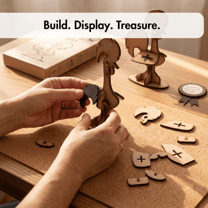 Hands assembling a wooden rooster-shaped craft piece on a cork board, with other wooden pieces and a branded box nearby. The text overlay reads &