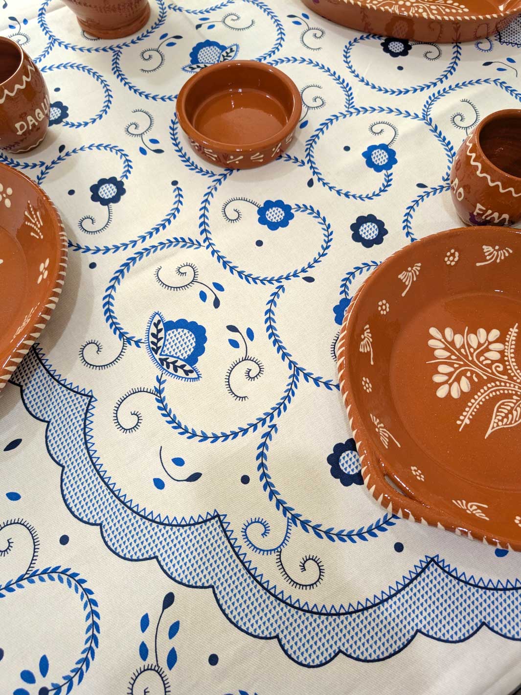 Ceramic plates and bowls on a tablecloth with blue patterns