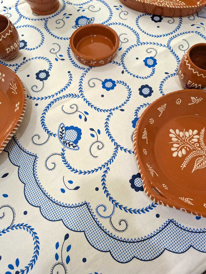 Ceramic plates and bowls on a tablecloth with blue patterns