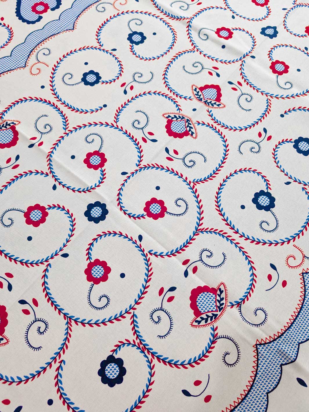 Close-up of a fabric with intricate patterns and colors on a white background