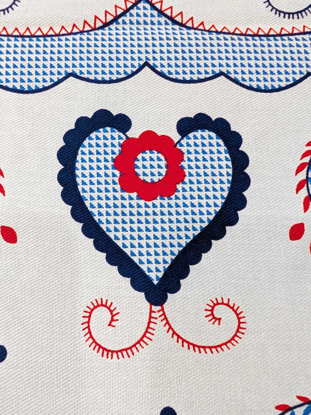 Fabric with heart and flower pattern in blue, red, and white