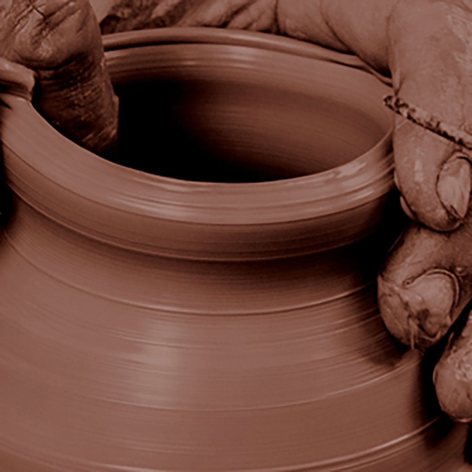 Portuguese artisan giving shape with his hands to traditional terracotta clay pots.