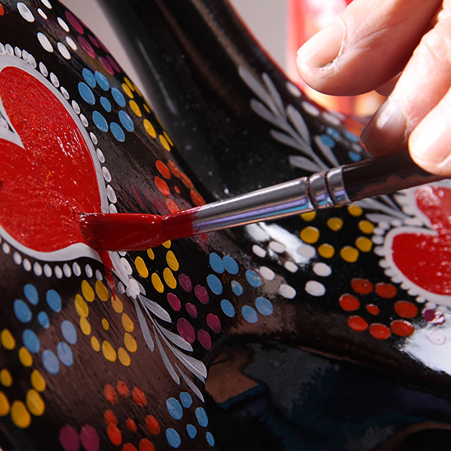 Portuguese artisans painting a Barcelos Rooster by hand.